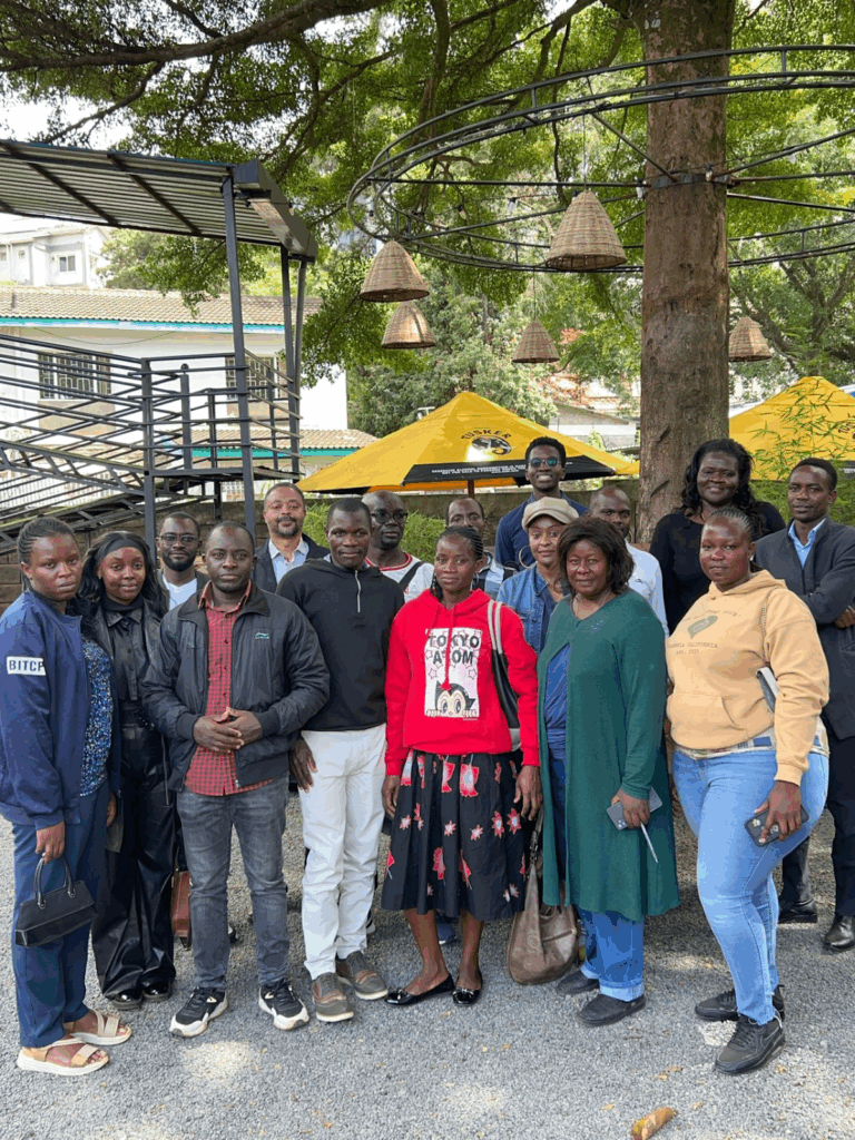 A group photo of all participants in the Kenyan TeacherMatic pilot, standing together outdoors under trees.